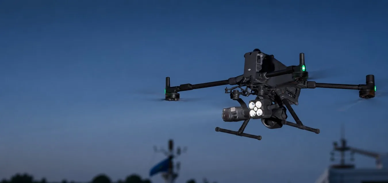 Дрон DJI Matrice 400 с прожектором Zenmuse S1 и камерой Zenmuse H30T в вечернем небе
